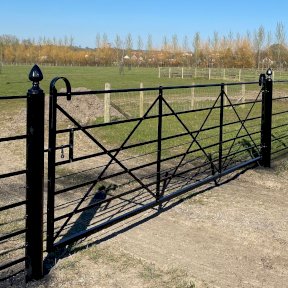 Vehicle gate with scrollwork and decorative gate posts
